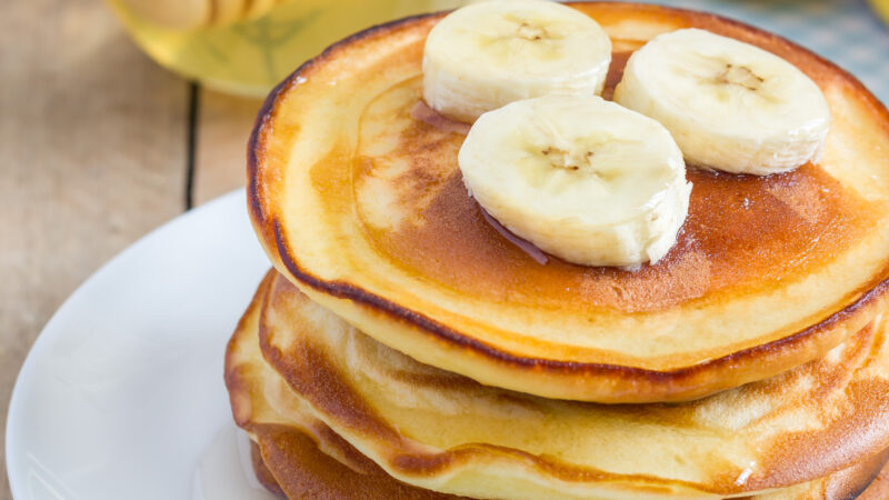 Stack of pancakes with banana and honey, closeup